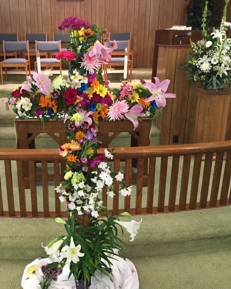 The Easter cross in the sanctuary, covered in flowers